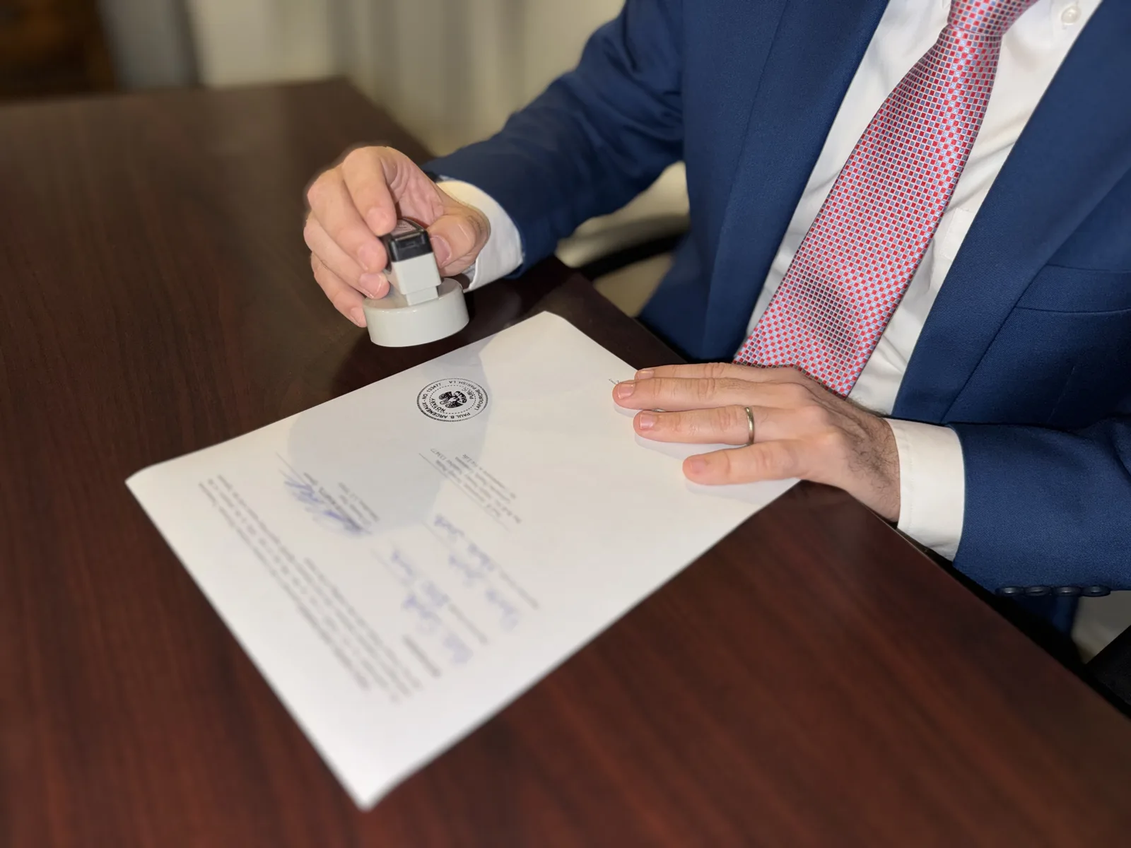 Paul Arceneaux applying a notarial seal to a legal document